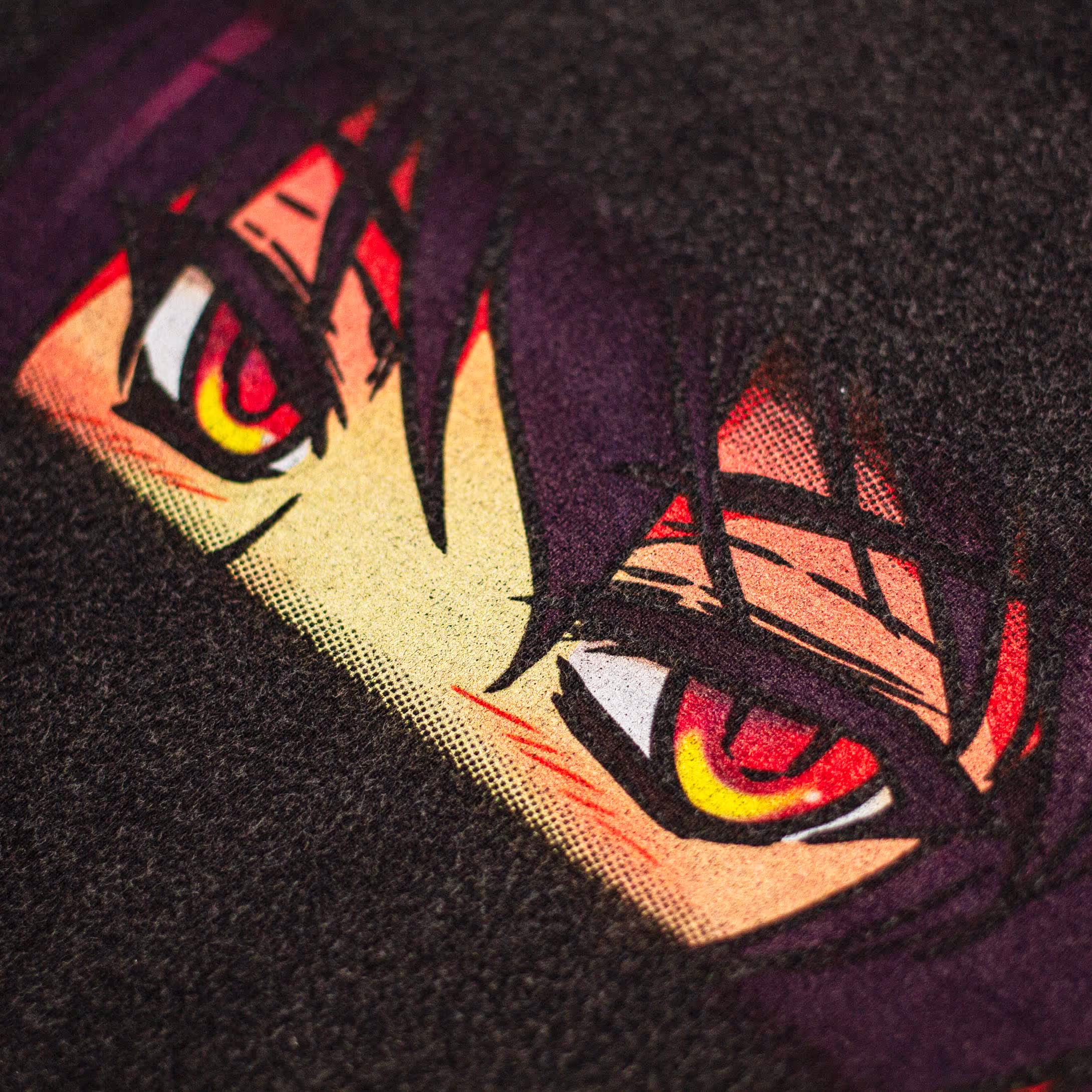 Close-up look of the front of Straygang's "nostalgia" black wash t-shirt, highlighting the digital print that portrays anime-styled eyes.