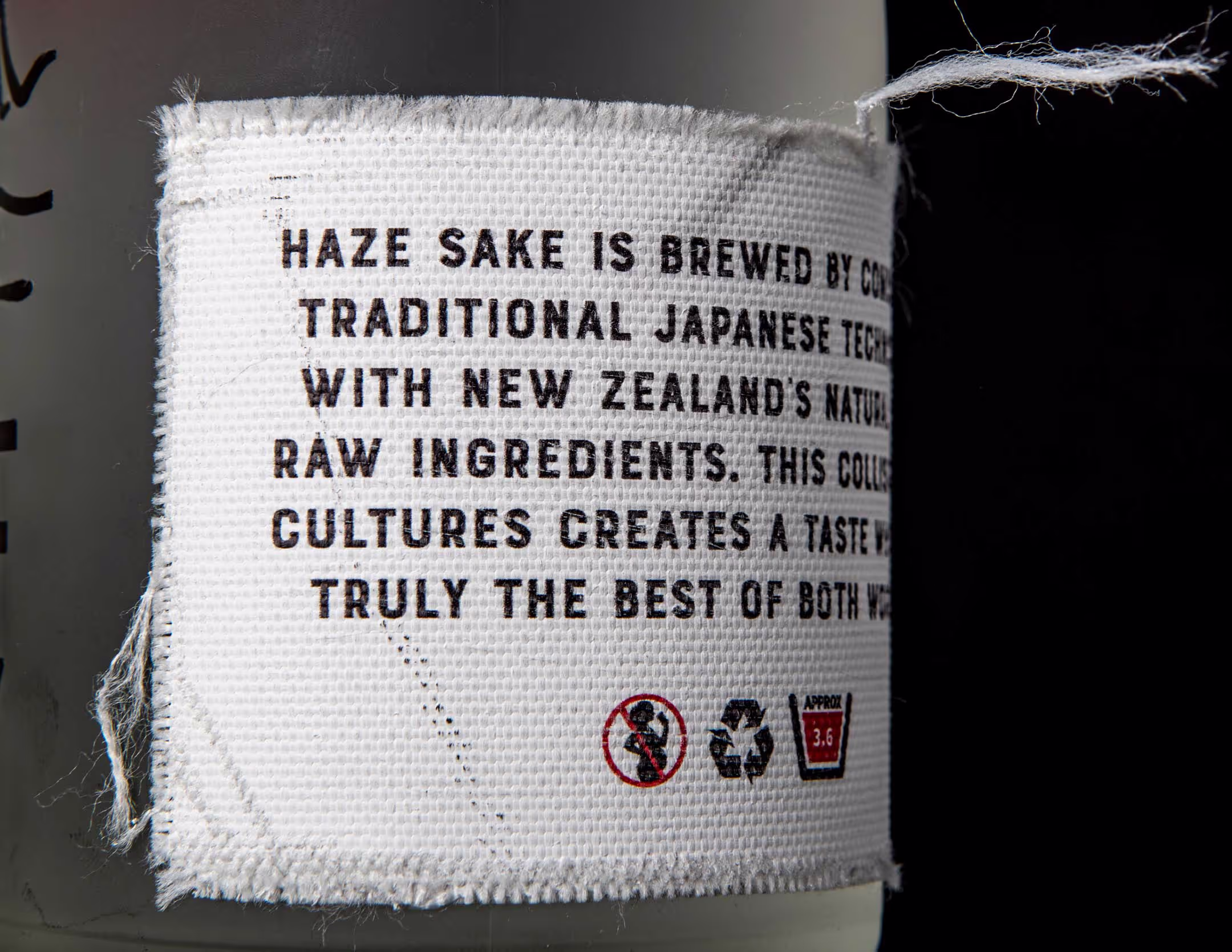 A close-up look at the canvas-like, ink-printed label on the back of the Haze Sake bottle, showing the level of detail featured on the product.